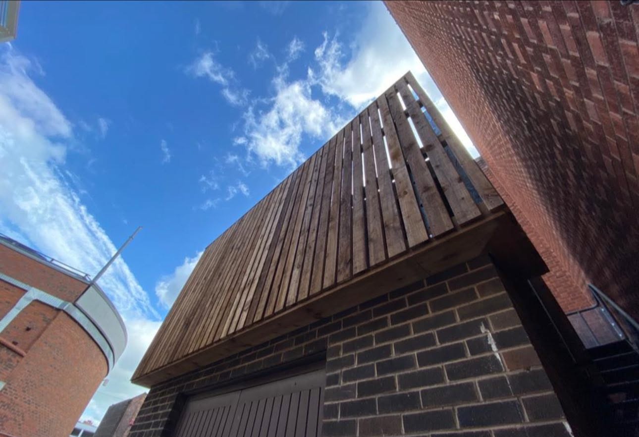 Bespoke vertical timber slat screen fitted to a brick building