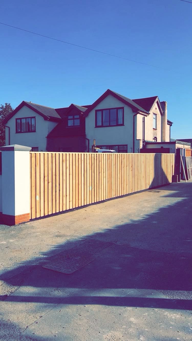 Vertical timber board fencing on a rendered wall in front of a residential property